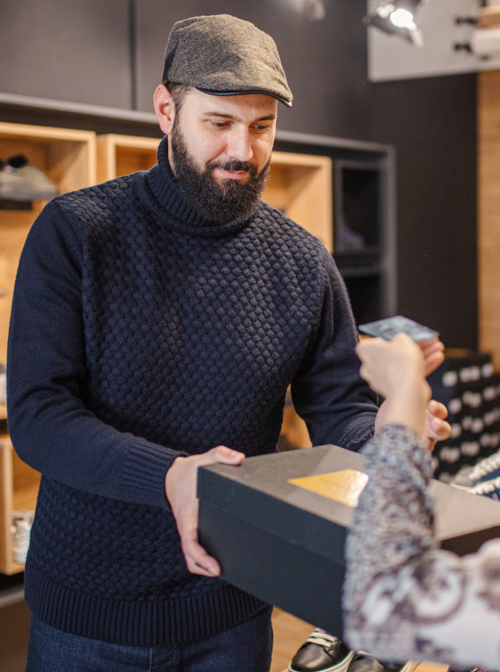 Retailer making a sale with a customer and handing over purchase