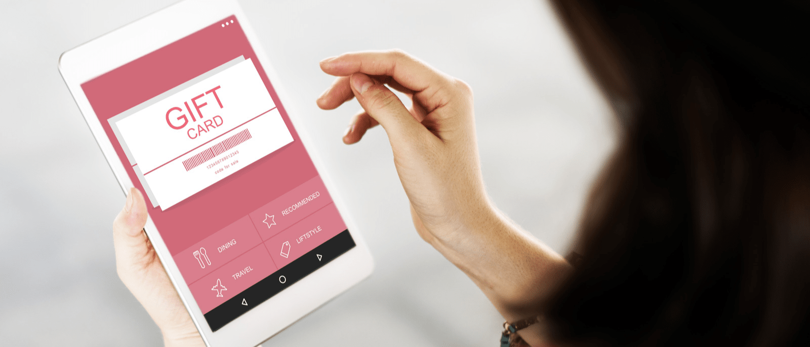 A woman using an online gift card on an iPad.